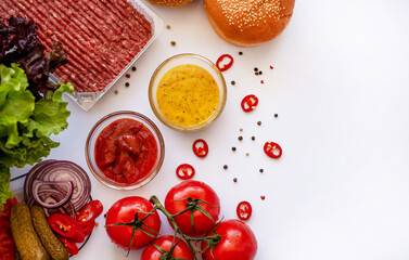 Set of different ingredients for making a burger on a white background. Cooking a burger. Homemade hambrger. Top view with free space for your text.