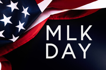 Fototapeta Black background and American Flag with text abbreviation MLK. Flat lay. Happy Martin Luther King Day concept obraz