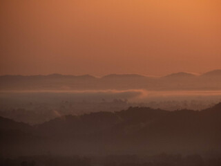 Fototapeta premium Amazing Sunrise Over Misty Landscape. Scenic View Of Foggy Morning Sky With Rising Sun Above Misty Forest