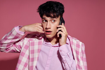 portrait of a young man with a phone in hand pink blazer fashion elegant style Lifestyle unaltered