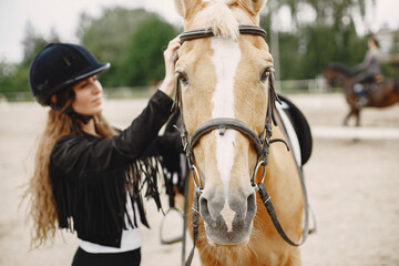 Portrait of riding horse with woman in black helmet