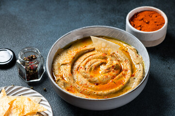 Traditional arabian eggplant dip baba ganoush with herbs and smoked paprika on dark background. Eggplant hummus. Babaganush or eggplant caviar. Baked eggplant. Turkish eggplant dip