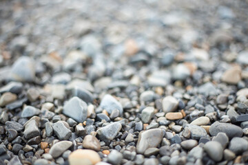 background of wet pebbles, selective focus, back part out of focus. grey and brown tones. stones from the seashore.