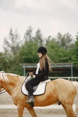 Foto op Canvas Portrait of woman in black helmet riding a brown horse © hetmanstock2