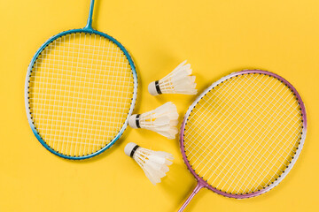 Badminton shuttlecock and badminton racket on yellow background