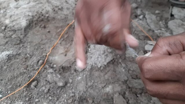 Blaster Specialist Connecting Dynamite Inside Rock. A Laborer Is Connecting Dynamite Wire To Blast The Rock