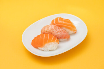 Assorted sushi on small white dish top view