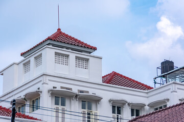 vintage and old white heritage building architecture under the clear and bright blue sky at Braga street Bandung