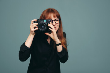 Skilful female photographer taking a picture on her digital camera