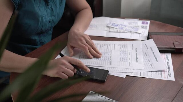 Financial crisis during Covid -19 period. The woman at home keeps the family budget. Accounting of monthly income and expenses, utility, bill, credit