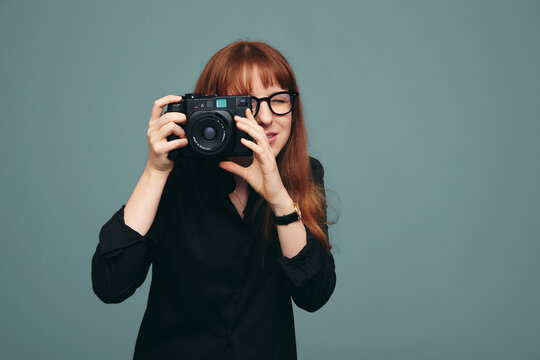 Skilful female photographer taking a picture on her digital camera