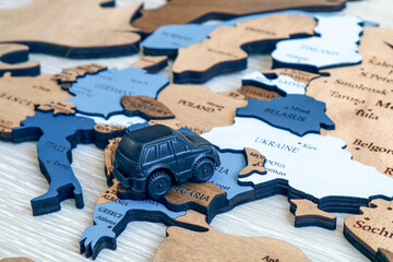 Toy car on a wooden map background. Travel and tourism concept. Europe close up