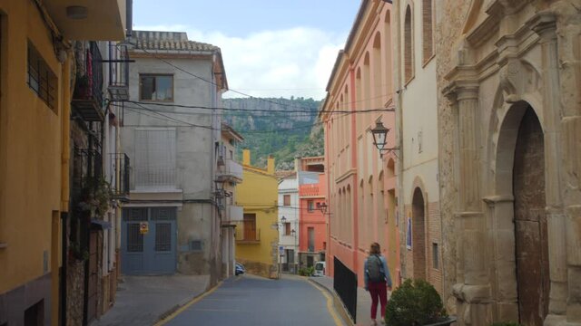 Traditional Structures Of Jerica Historic Town With Lone Woman Walking On The Street In Castellon Province, Spain. Tilt-down