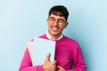 Young mixed race student man isolated on blue background laughing and having fun.