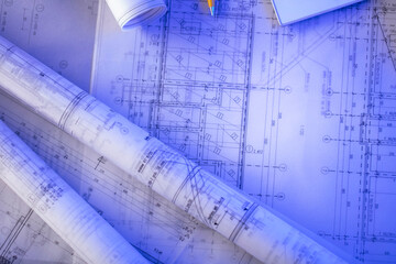 Contractor theme. Tool kit of the contractor: yellow hardhat, libella, hand saw. Plans and notebook on the desk.