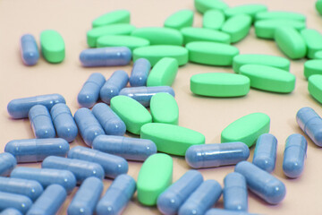 Bright pills are scattered on a pale background. The concept of treatment, health, medical theme, the fight against depression