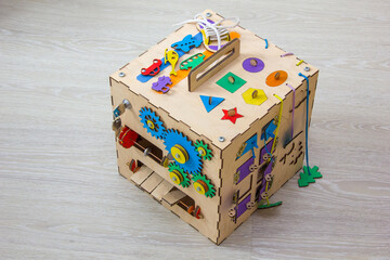 Handmade coloredbusy cube from plywood. Educational toy for children, game panel