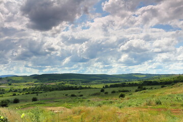 Fototapeta na wymiar view of the green valley stretching beyond the horizon bright cloudy sky