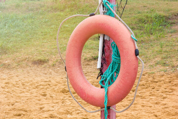 The lifebuoy for drowning set on a sandy beach with grass. Help drowning in expectation