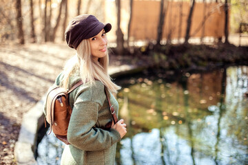 Portrait of a young happy woman tourist on a lake in the autumn forest