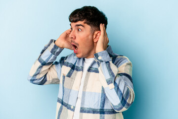 Young mixed race man isolated on blue background screaming, very excited, passionate, satisfied...