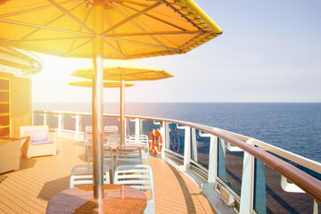 The liner in the open ocean, a place to relax, tables and umbrellas on the deck. Ship resting place