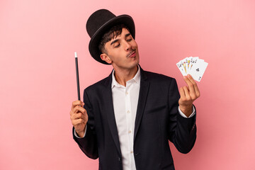 Young caucasian wizard man holding a magic cards and wand isolated on white background