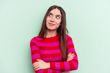 Young caucasian woman isolated on green background dreaming of achieving goals and purposes