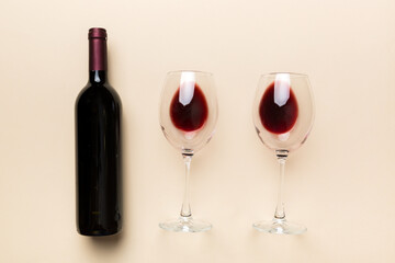 Glass of red wine and a bottle on colored table. Flat lay, top view wth copy space