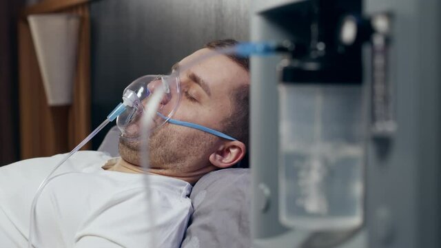 Close-up shot of man on oxygen concentrator at home due to hospital beds available for people with coronavirus infection covid-19 - concept of medical bed shortage in clinic