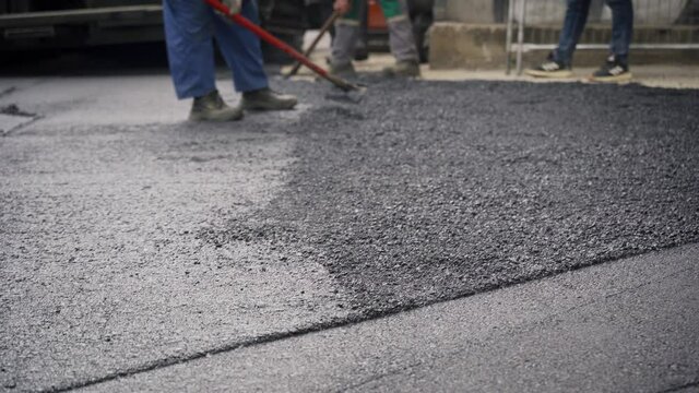 Workers Laying Asphalt and Straightening it for a New Road Infrastructure Project, Handheld