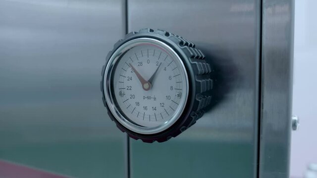 Pointer thermometer on industrial equipment, where the upper and lower temperature ranges are set. Shot in motion. Closeup