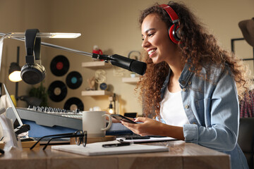 African American woman working as radio host in modern studio