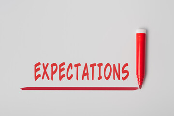 The word 'Expectations', written with red marker over red line, isolated on gray background