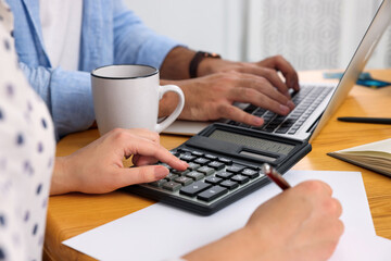 Young couple discussing family budget at table, closeup