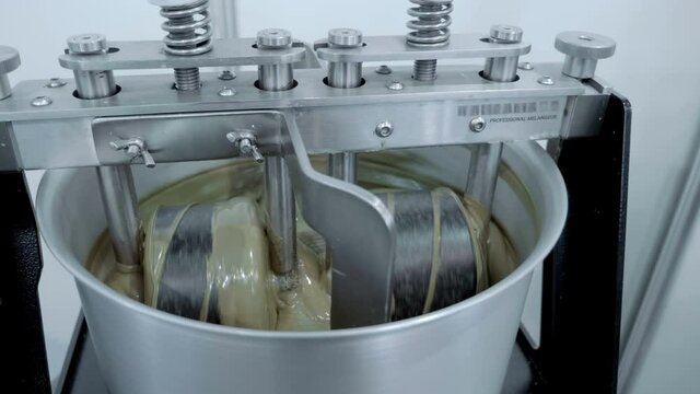 Industrial equipment for making white chocolate. Grated cocoa is subjected to long-term continuous intensive stirring at a temperature of 55 to 90 &deg; C. Shot in motion. Closeup