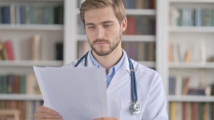 Portrait of Doctor Reading Documents in Office 