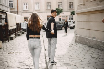 Two lovers holding a hands on the streets of the old city during a date