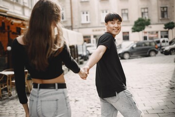 Two lovers holding a hands on the streets of the old city during a date