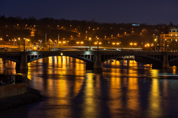 Fototapeta na wymiar Prague at night, view of bridges on the Vlatava river, reflection of night city lights, cityscape