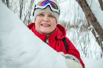 Fototapeta na wymiar Grandmother walks in the winter snow-covered park.
