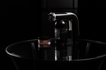A close-up of the instant tanning equipment. Gun spraying paint for leather and matting body powder on a black background