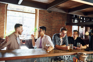 At daytime. People in casual clothes sitting in the pub