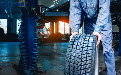 Seasonal tire changeover in auto service. Tire swap background with copy space. Winter tire storage.