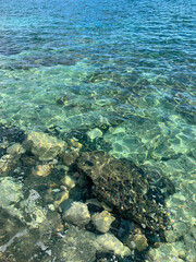 Transparent sea surface, lagoon, pebbles and stones, ripples on the sea surface