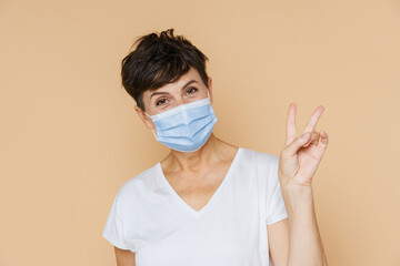 Mature european woman gesturing while posing in face mask