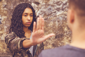 Confident south american hipster woman gesturing stop to boyfriend