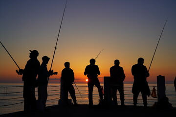 Fototapeta na wymiar fishermen on the background of the sea sunset