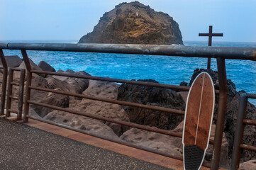 a skateboard is accountable to a cross facing the sea