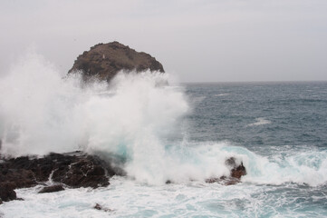 the sea hits the rocks and the islet hard